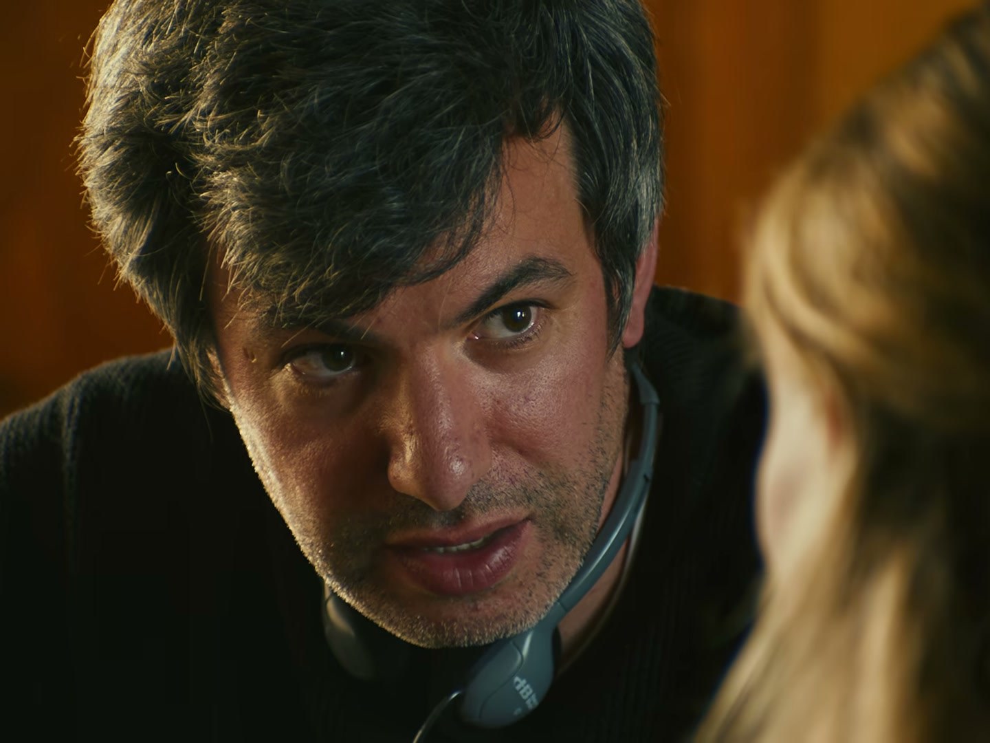 Nathan Fielder pochylony nad stołem. Owen Gleiberman z Variety porównał jego beznamiętność do Stevena Wrighta